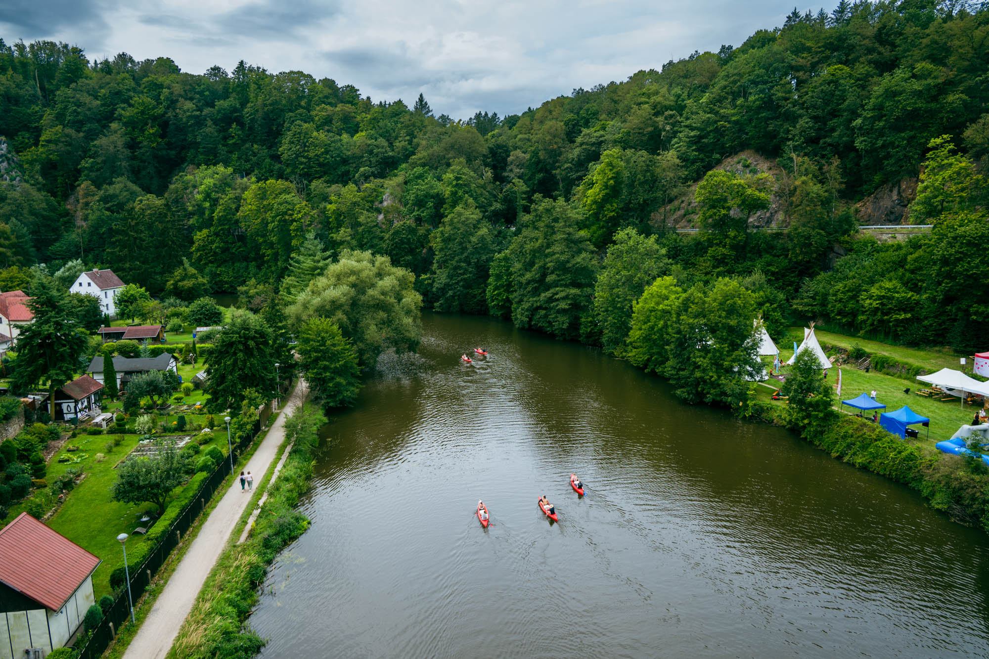 Blick auf den Fluss von der anderen Seite der Brücke. Das Festival thematisiert das  Wilden Westen und besiedlung von Amerika. Auf der rechten Seite erkennt man Tipis - die Behausung Amerikas Ureinwohner.