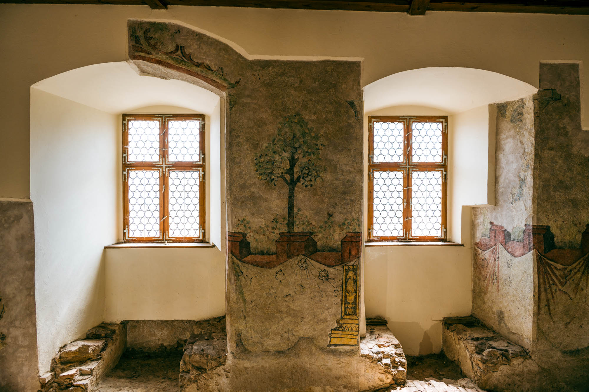 Dieses Gemälde hat eine Geschichte. Es zeigt eine Landschaft außerhalb der Burgmauern, die vor langer Zeit aufgenommen wurde. Als das Mittelalter abgeschafft wurde, wurde die Burg einfach in eine Kaserne und später in ein Gefängnis umfunktioniert. Das Gemälde wurde mehrere Male verputzt und verschwand praktisch aus der Geschichte. Zum Glück hat man die Bilder bei der Restauration gefunden und vor dem Vergessen gerettet.